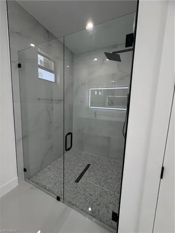 Full bath featuring a marble finish shower and recessed lighting