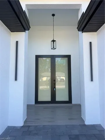 Entrance to property with stucco siding and french doors
