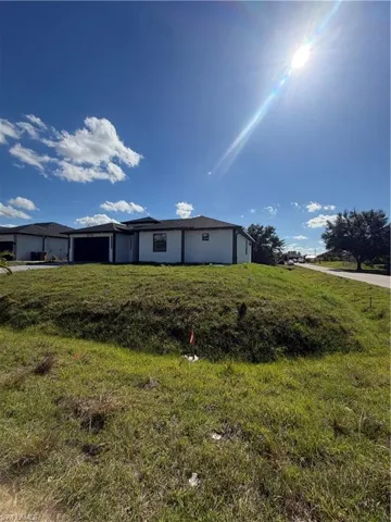 Back of house featuring stucco siding and a yard