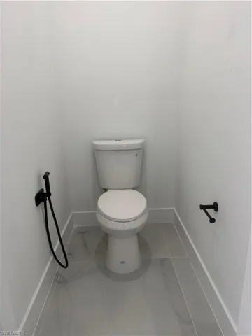 Bathroom featuring baseboards and toilet
