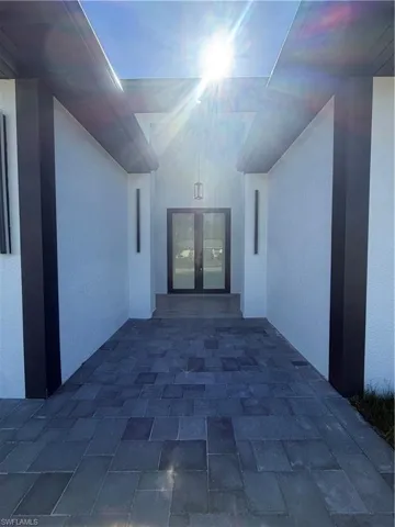 View of exterior entry with stucco siding, a patio area, and french doors