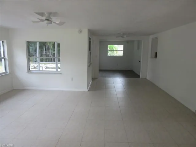 Empty room featuring ceiling fan and light tile patterned floors