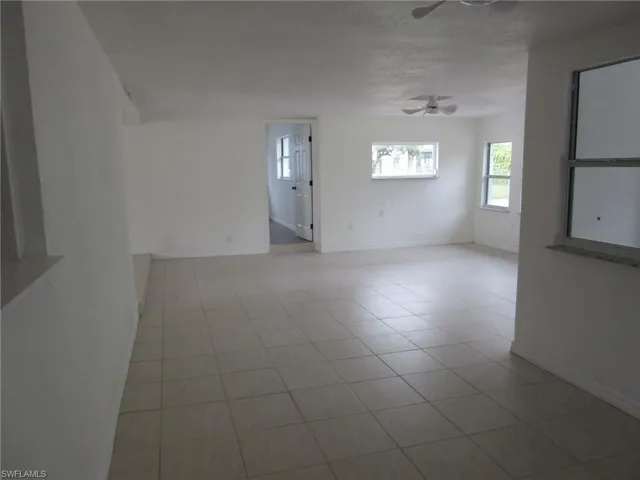 Spare room featuring ceiling fan, light tile patterned flooring, and a textured ceiling