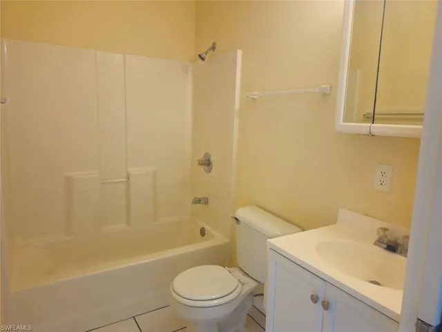 Bathroom with tile patterned floors, vanity, and shower / tub combination
