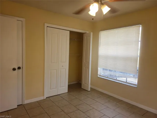 Unfurnished bedroom featuring light tile patterned floors, a ceiling fan, and a closet