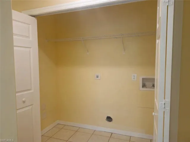 Laundry room with tile patterned flooring and hookup for a washing machine