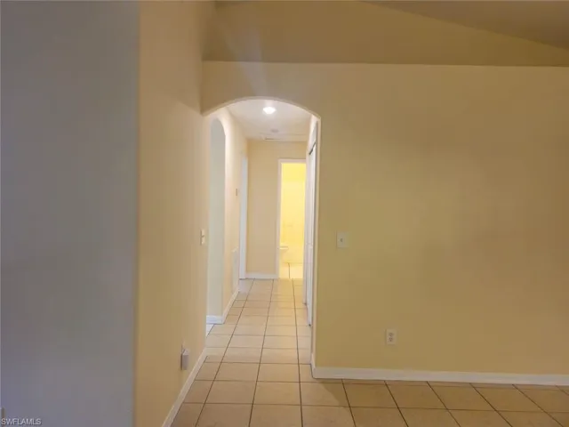 Corridor with light tile patterned floors and arched walkways