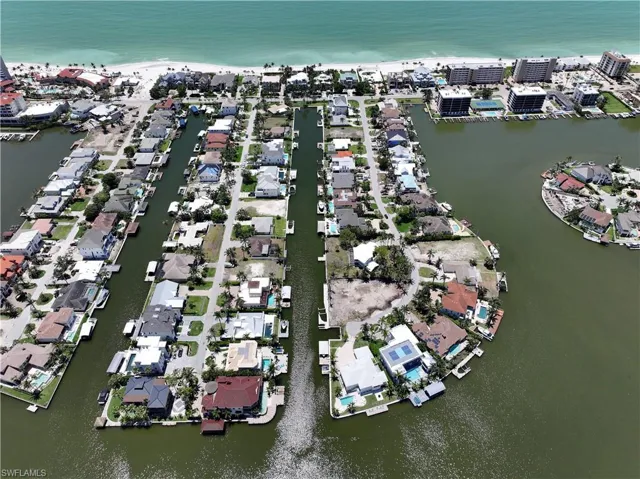 Aerial view of property and surrounding area with a nearby body of water and nearby suburban area