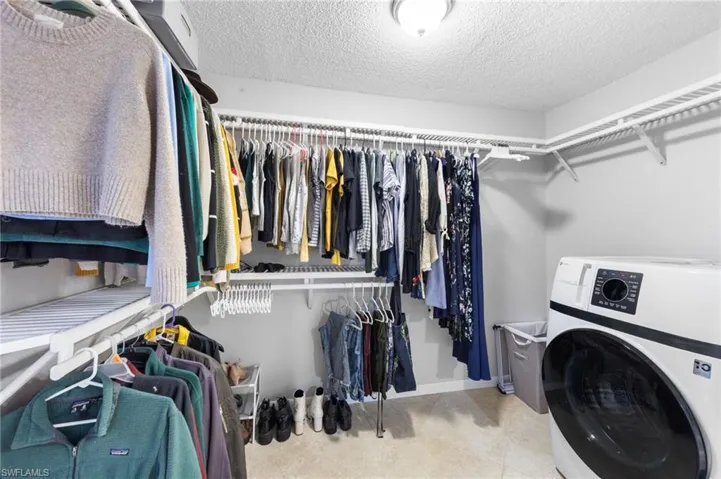 Walk in Primary Closet with brand new ventless washer dryer combo.