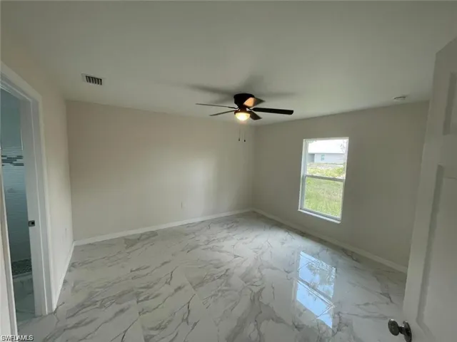 Unfurnished room with light marble finish flooring and a ceiling fan