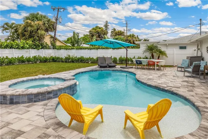 View of pool with an in ground hot tub and a patio