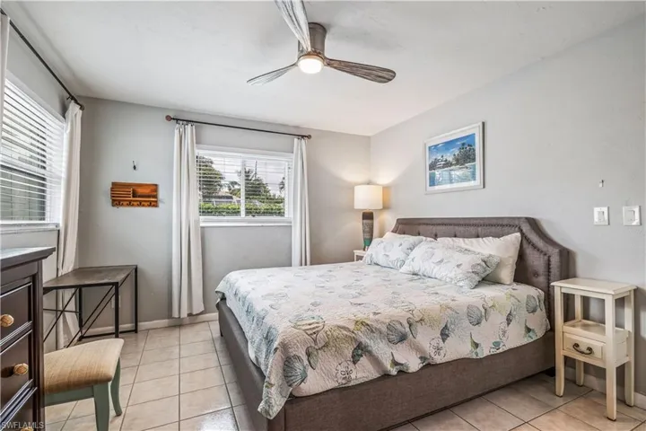 Tiled bedroom featuring ceiling fan