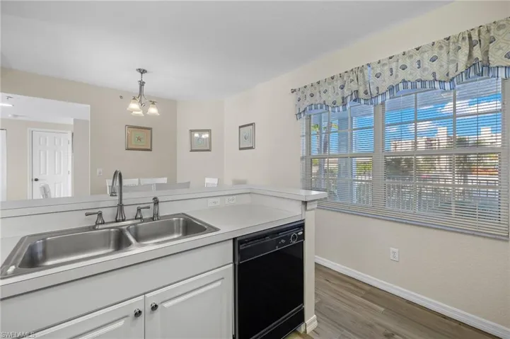 Kitchen Window Out To Screened in Front Porch Providing Plenty Of Warm Daylight - Virtually Enhanced Photo