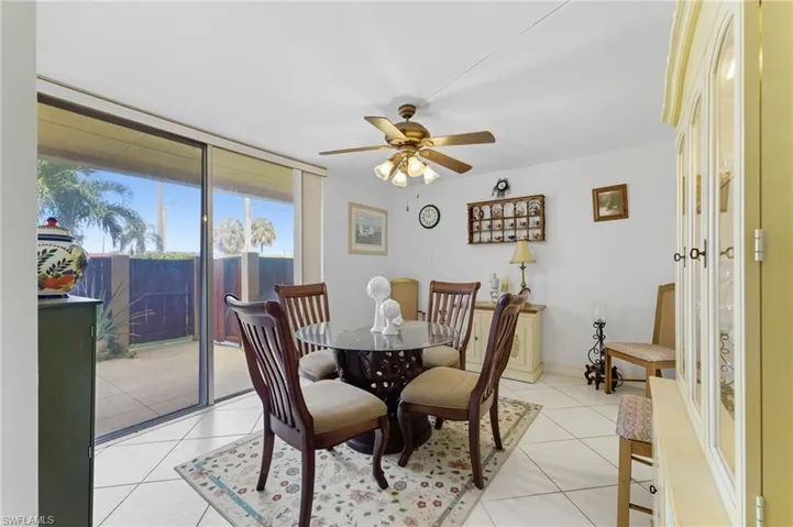 Dining space featuring light tile patterned flooring, a ceiling fan, and expansive windows
