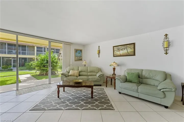 Living room with tile patterned floors and a wall of windows