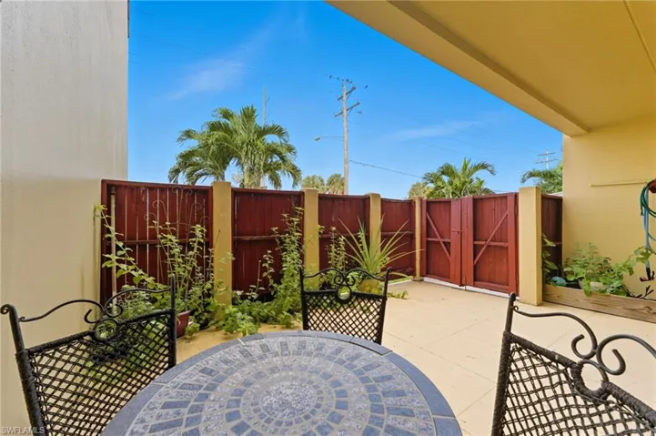 View of patio with a gate and outdoor dining area