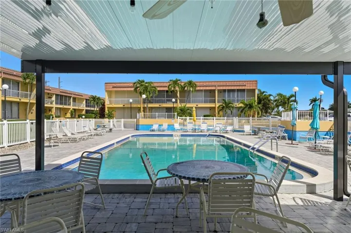 Community pool with a patio area and ceiling fan