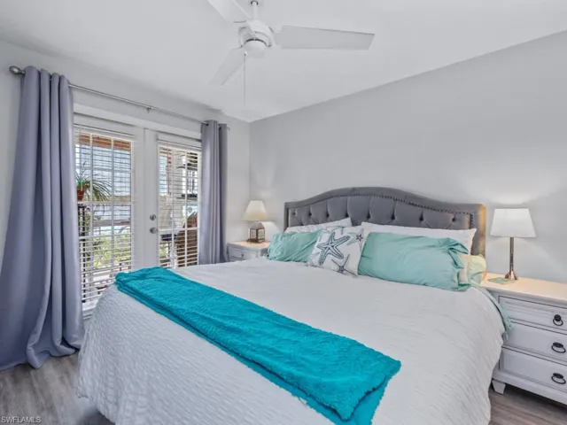 Bedroom with access to exterior, wood finished floors, french doors, and a ceiling fan