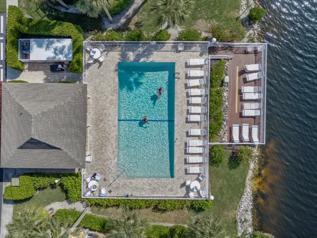 Drone / aerial view of a pool and a nearby body of water