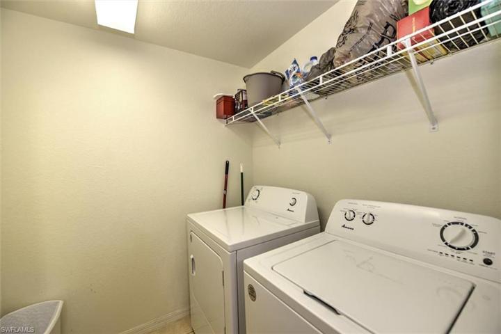 In-unit side-by-side washer/dryer in tiled laundry room with storage shelf!