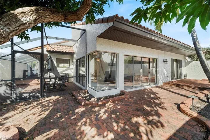 Rear view of property with a patio area and glass enclosure