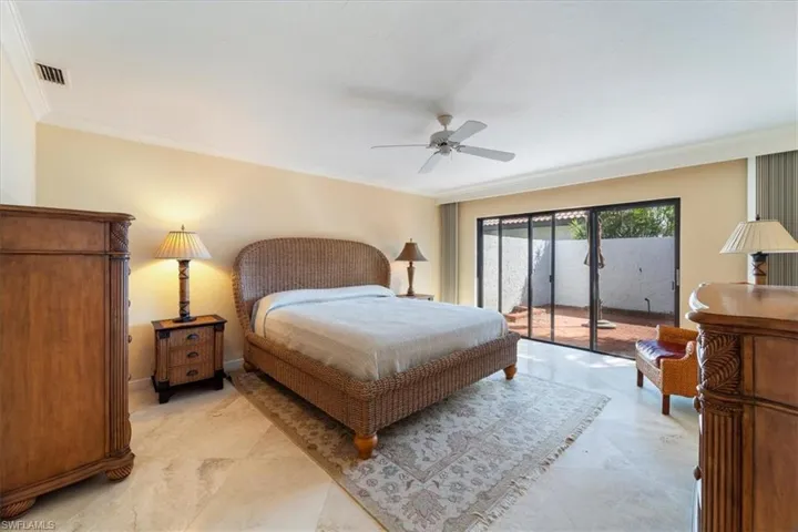 Bedroom featuring ceiling fan, ornamental molding, and access to outside