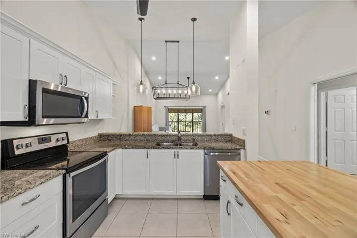 Kitchen with granite counters, contemporary pendant lights opening to great room