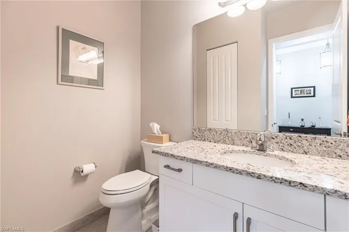 Bathroom featuring vanity, toilet, tile patterned floors, and baseboards