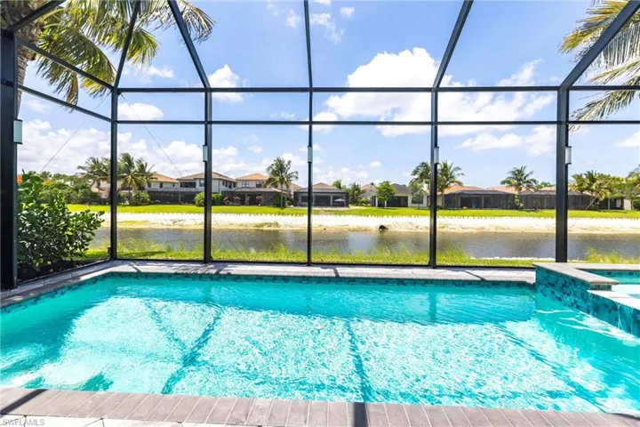 View of pool featuring a lanai, a water view, a residential view, and a pool with connected hot tub