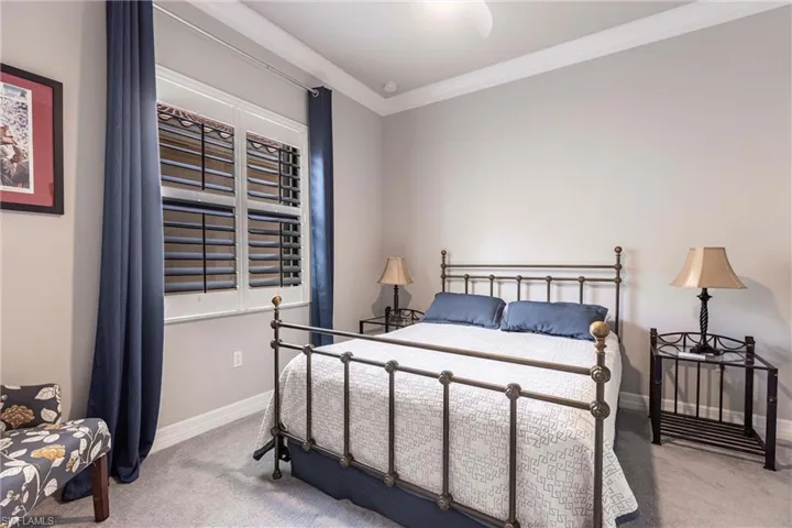 Carpeted bedroom featuring baseboards and crown molding