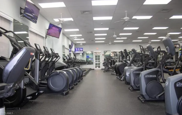 Workout area featuring a ceiling fan and a paneled ceiling