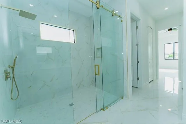 Bathroom with marble tiled flooring and a marble finish shower