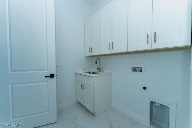 Laundry room featuring hookup for a washing machine, light marble finish floors, cabinet space, and electric dryer hookup