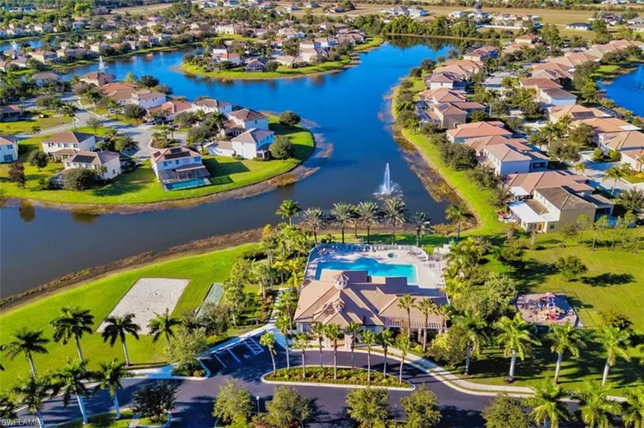 Aerial perspective of suburban area with a large body of water and a pool area