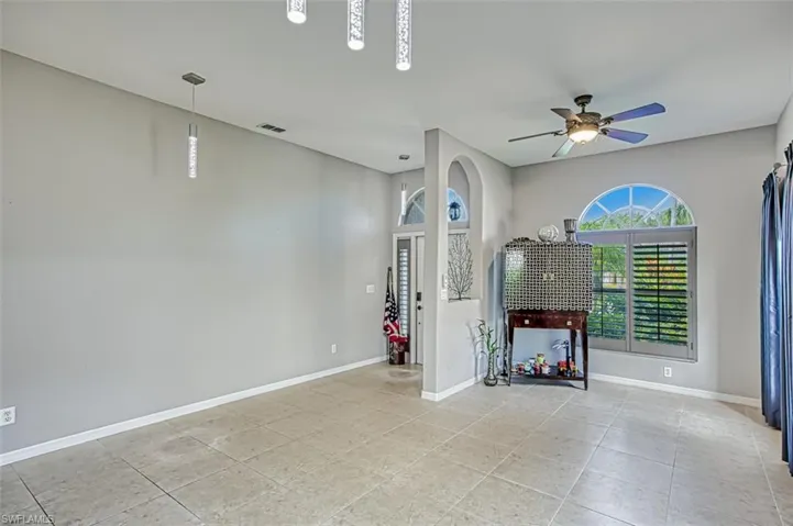 Empty room featuring ceiling fan and light tile patterned flooring