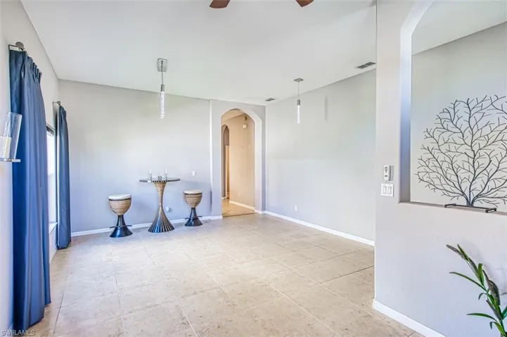 Empty room with arched walkways and a ceiling fan