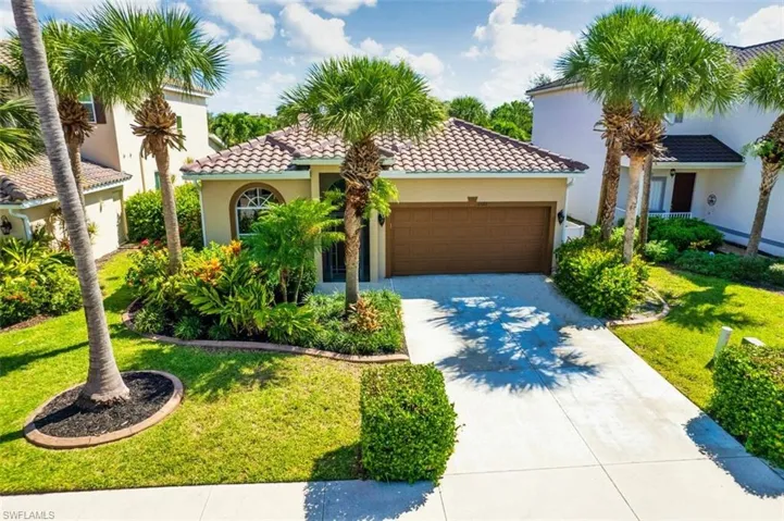 Mediterranean / spanish-style home featuring stucco siding, an attached garage, driveway, and a front lawn