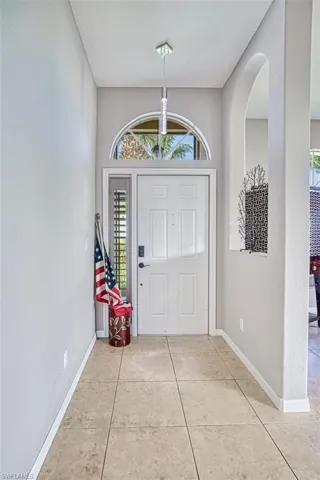 Entryway featuring light tile patterned floors and arched walkways