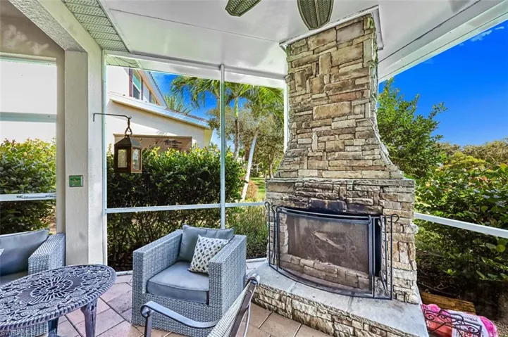 Sunroom featuring an outdoor stone fireplace