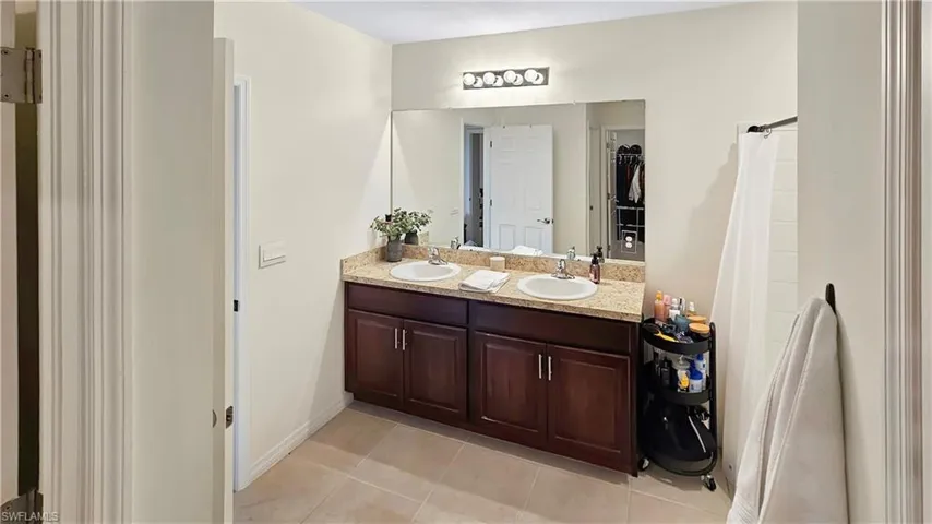 Bathroom with tile patterned flooring, a sink, and double vanity