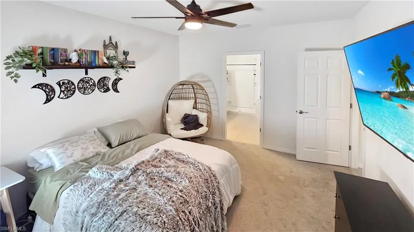 Bedroom featuring baseboards, visible vents, a ceiling fan, light colored carpet, and ensuite bathroom