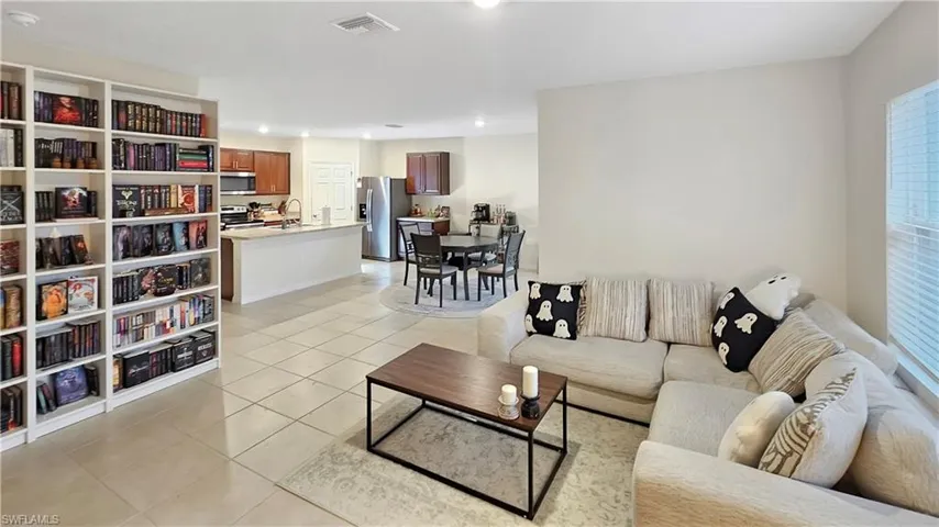 Living area with light tile patterned floors, visible vents, and recessed lighting