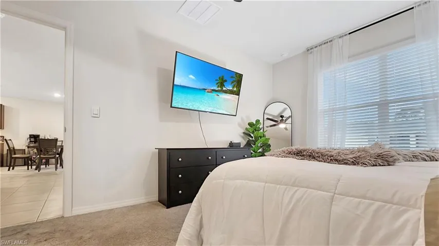 Bedroom featuring baseboards, visible vents, and light colored carpet