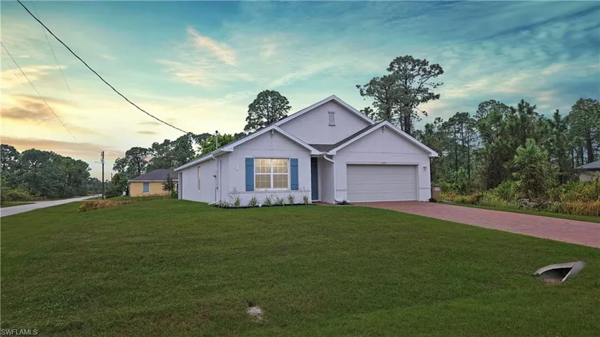 Ranch-style house with a garage, decorative driveway, and a front yard