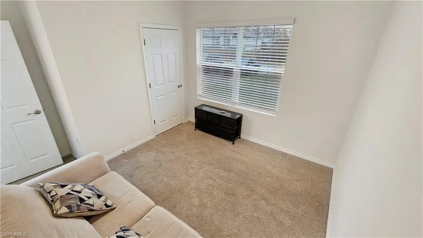 Bedroom with light carpet and baseboards