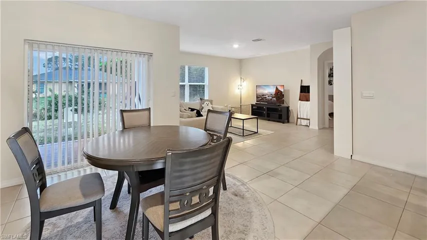 Dining space with arched walkways, light tile patterned flooring, and baseboards