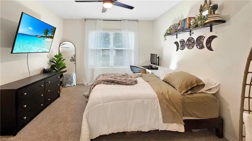 Bedroom with ceiling fan, baseboards, and light colored carpet