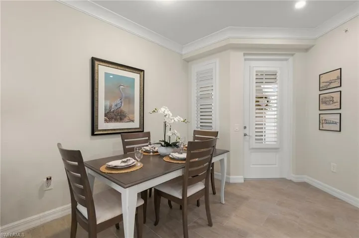 Dining room with light wood-type flooring, baseboards, and ornamental molding