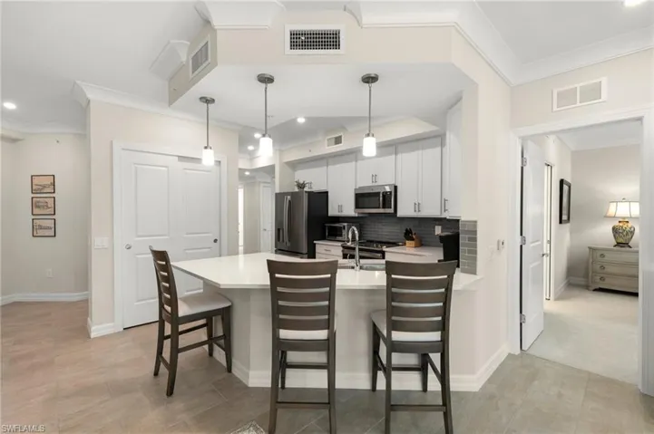 Kitchen with visible vents, a peninsula, stainless steel appliances, and light countertops
