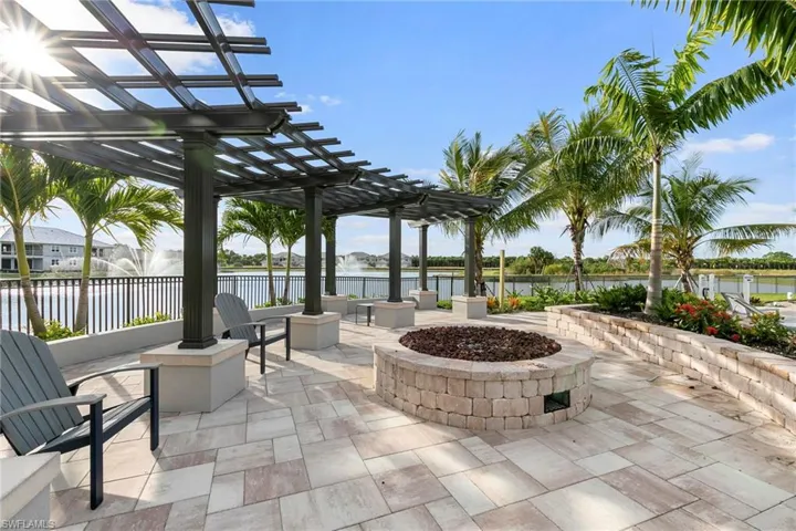 View of patio with fence, a pergola, a water view, and an outdoor fire pit